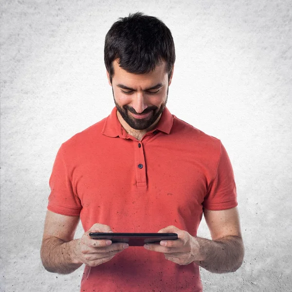 Hombre guapo sosteniendo una tableta — Foto de Stock