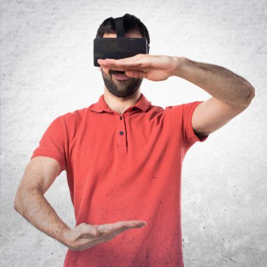 VR glassesa kullanarak ve bir şey tutan yakışıklı adam