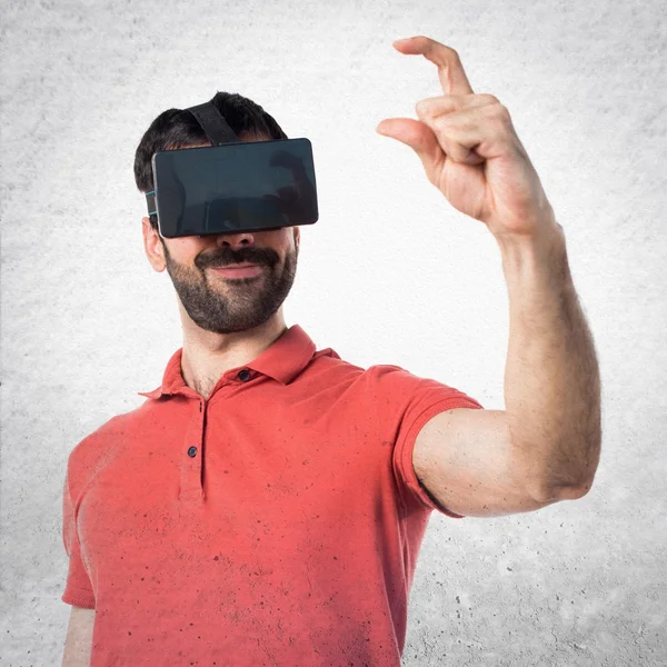 Handsome man using VR glassesa and holding something — Stock Photo, Image