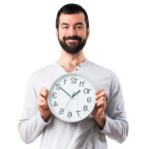 Man in pajamas holding clock — Stock Photo, Image