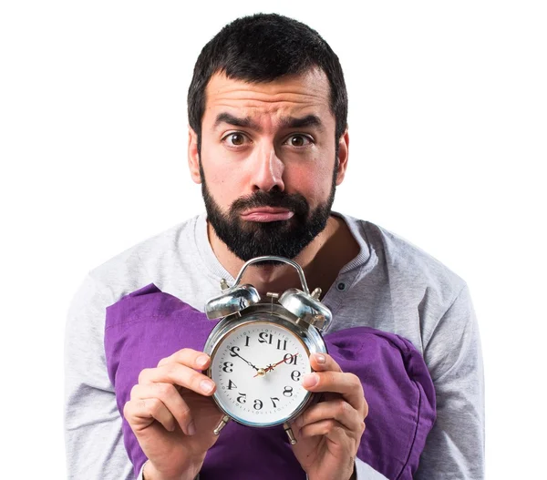 Человек в пижаме держит винтажные часы — стоковое фото