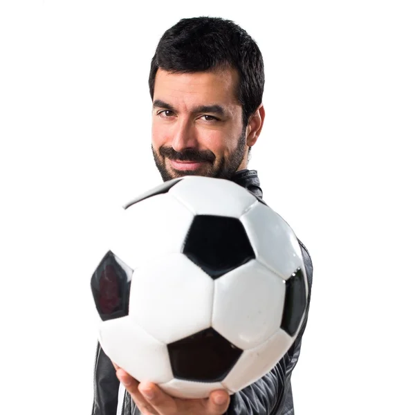Hombre con chaqueta de cuero sosteniendo una pelota de fútbol — Foto de Stock