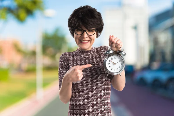 Brunette girl holding vintage clock — Stock Photo, Image