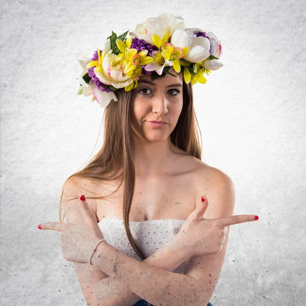 Dziewczyna z korony kwiatów, wskazując przykanalików o wątpliwości — Zdjęcie stockowe
