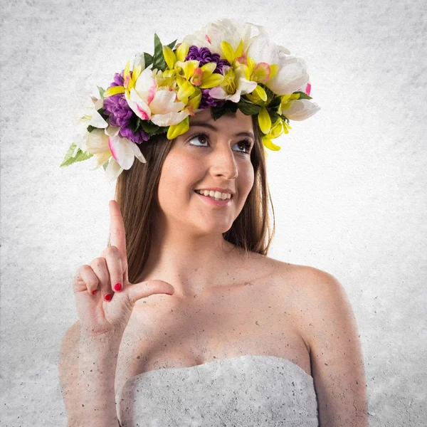 Menina com coroa de flores apontando para cima — Fotografia de Stock