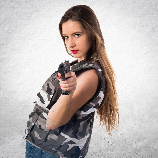 Ung flicka håller en pistol — Stockfoto
