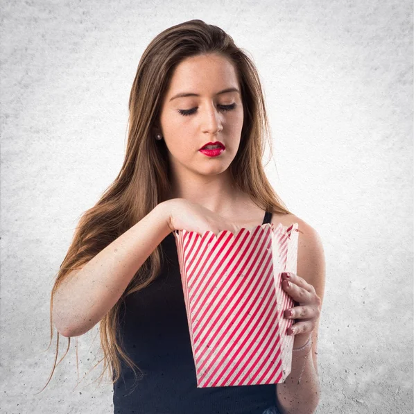 Fiatal lány eszik popcorns — Stock Fotó