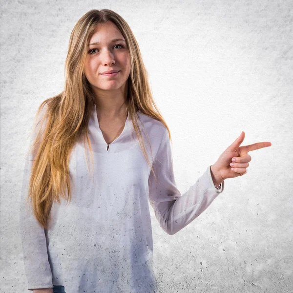 Menina adolescente apontando para o lateral — Fotografia de Stock