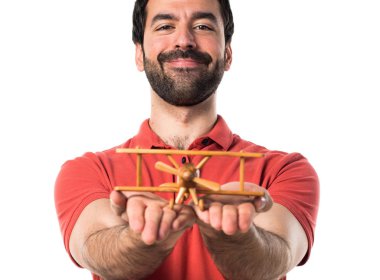 Yakışıklı adam ahşap oyuncak uçak holding