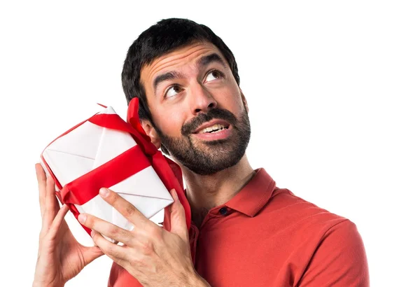 Handsome man holding a gift — Stock Photo, Image