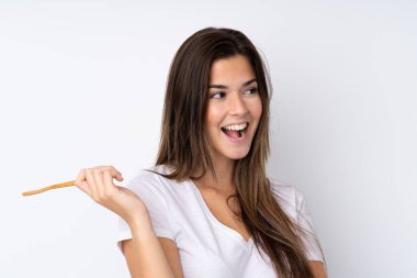 İzole edilmiş, diş fırçası ve şaşırmış ifadesiyle genç bir kız.