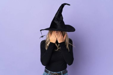 Cadı kostümlü genç bir kadın, izole edilmiş bir geçmişi var, yorgun ve hasta bir ifadesi var.