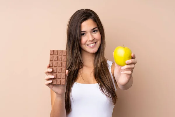 Teenager Dívka Přes Izolované Pozadí Přičemž Čokoládovou Tabletu Jedné Ruce — Stock fotografie