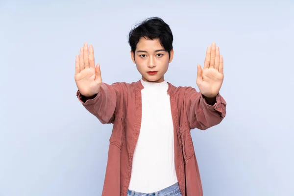 Joven Asiática Chica Sobre Aislado Azul Fondo Haciendo Stop Gesture — Foto de Stock