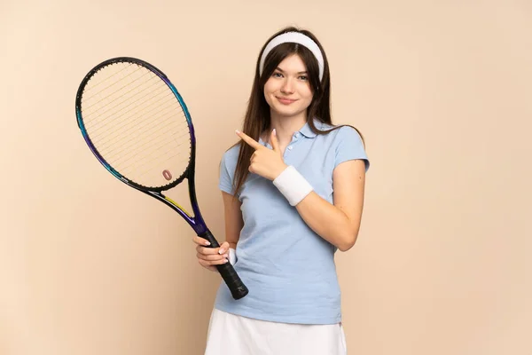 製品を提示するために側面を指して隔離された壁の上に若いウクライナの女の子テニス選手 — ストック写真