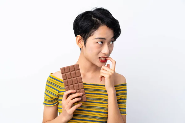 Giovane Ragazza Asiatica Prendendo Una Tavoletta Cioccolato Avendo Dubbi — Foto Stock