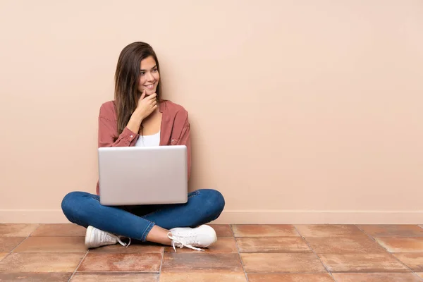 Adolescente Estudiante Chica Sentada Suelo Con Ordenador Portátil Mirando Lado — Foto de Stock