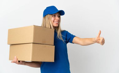 Beyaz arka planda izole edilmiş genç teslimatçı kadın iyi niyet gösterisi yapıyor. 