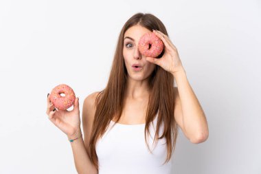 İzole edilmiş beyaz arka planı olan genç bir kadın elinde donut tutuyor.