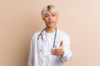 Genç Asyalı bir adam doktor önlüğüyle izole edilmiş bir geçmişi var ve bir anlaşma yapıyor.