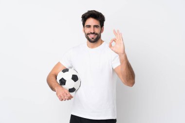 Sakallı yakışıklı genç adam izole edilmiş beyaz arka planda parmaklarıyla işaret veriyor.