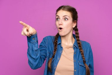 İzole edilmiş mor arka planı olan genç bir kadın.