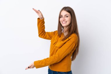 İzole edilmiş beyaz arka plan üzerinde genç bir kadın ilan vermek için kopyalama alanı tutuyor