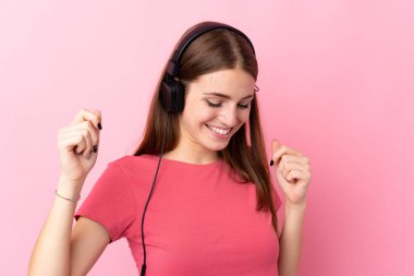 Soyutlanmış pembe arka plan müzik ve dans dinleyen genç bir kadın.