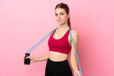 Genç sporcu kadın pembe arka planda, atlama ipiyle.