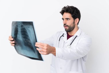 Sakallı, beyaz bir geçmişi olan, doktor önlüğü giymiş ve elinde kemik taraması yapan yakışıklı bir genç.
