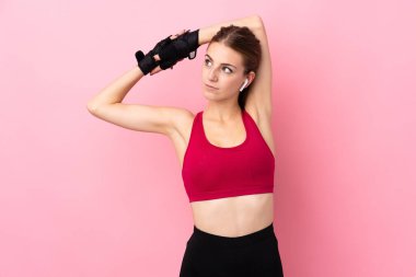 Soyutlanmış pembe arka plan gerinen genç bir kadın.