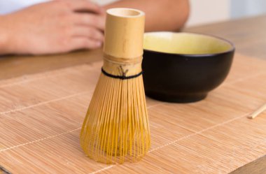 Masasında kibrit çayı olan genç Asyalı adam.