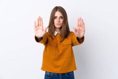 İzole edilmiş beyaz arka planda genç bir kadın dur hareketi yapıyor ve hayal kırıklığına uğruyor.