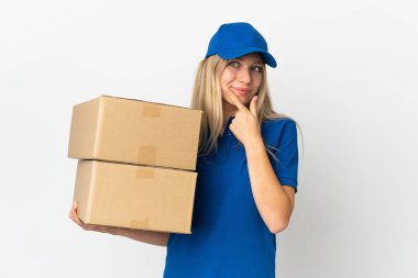Beyaz arka planda izole edilmiş genç teslimatçı kadın yana bakıyor ve gülümsüyor. 