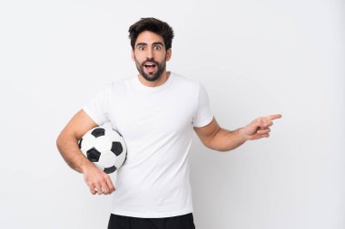 Sakallı, yakışıklı, soyutlanmış beyaz bir geçmişi olan, şaşırmış ve parmağını yana doğru gösteren genç bir adam.