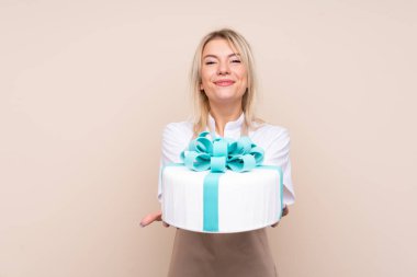 Soyutlanmış arka planda büyük bir pastası olan genç Rus kadın.