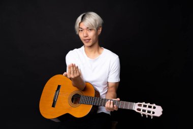 Siyah arka planda gitarı olan Asyalı genç bir adam benimle gelmesi için davet ediyor. Gelmene sevindim.