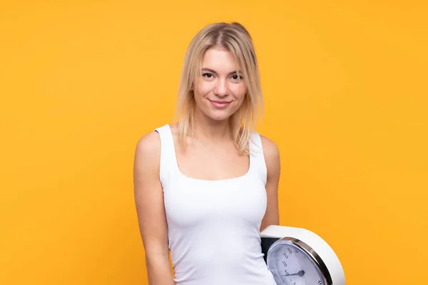 Young Blonde Russian Woman Isolated Yellow Background Weighing Machine — Stock Photo, Image