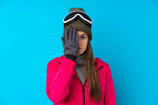 Nastoletnia Narciarka Okularach Snowboardowych Odizolowanym Niebieskim Tle Zasłaniającym Oko Ręcznie — Zdjęcie stockowe
