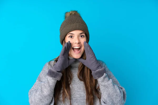 Kışlık Şapkalı Genç Kız Mavi Arka Planda Ağzı Açık Bağırıyor — Stok fotoğraf