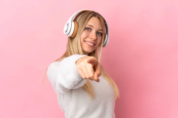 Mujer Rubia Joven Aislada Sobre Fondo Rosa Escuchando Música Señalando — Foto de Stock