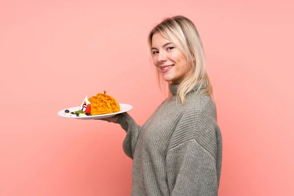 Jovem Loira Segurando Waffles Sobre Fundo Rosa Isolado Sorrindo Muito — Fotografia de Stock