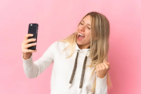 Giovane Donna Bionda Isolata Sfondo Rosa Utilizzando Telefono Cellulare Facendo — Foto Stock