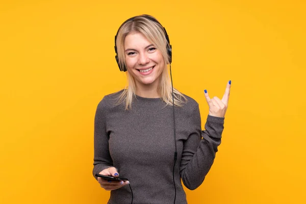 Jeune Femme Blonde Sur Fond Jaune Isolé Écoutant Musique Faire — Photo