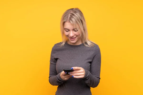 Junge Blonde Frau Über Isoliertem Gelben Hintergrund Sendet Eine Nachricht — Stockfoto
