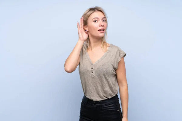 Ung Blond Kvinna Över Isolerad Blå Bakgrund Lyssna Något — Stockfoto