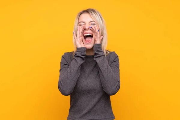 Joven Rubia Sobre Fondo Amarillo Aislado Gritando Anunciando Algo —  Fotos de Stock