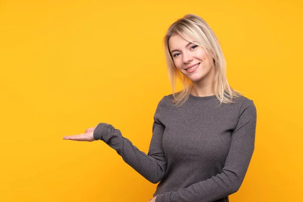 Jonge Blonde Vrouw Geïsoleerde Gele Achtergrond Presenteren Van Een Idee — Stockfoto