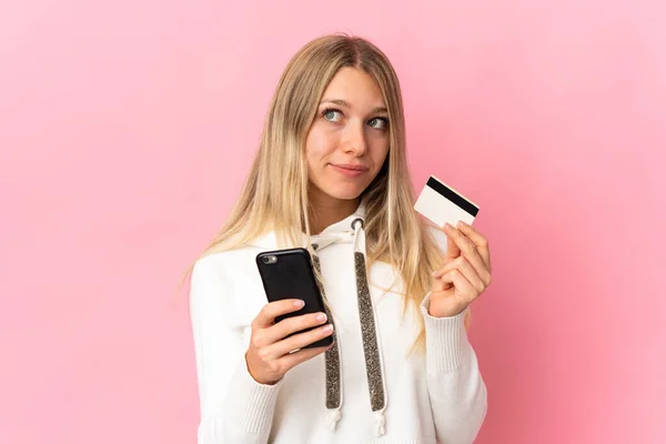 Mladé Blondýny Žena Izolované Růžovém Pozadí Nákup Mobilem Kreditní Kartou — Stock fotografie
