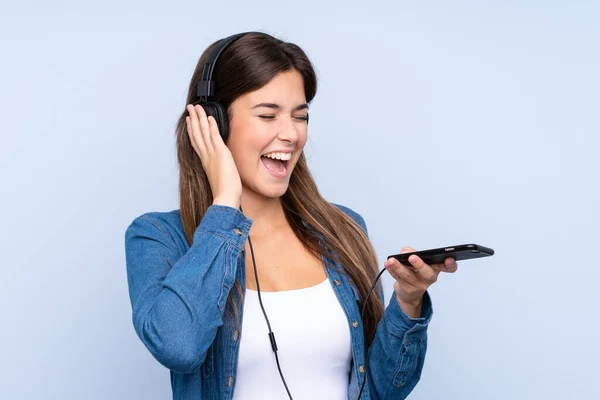 Tiener Braziliaanse Meisje Luisteren Muziek Zingen Geïsoleerde Blauwe Achtergrond — Stockfoto
